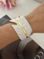 Elegante brede witte emaille veren armband met gouden aderdetails gedragen om de pols - Breed Blad Wit