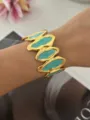 Elegante brede goudkleurige open armband met levendige turquoise emaille elementen - Onregelmatige Ovaal Meerblauw