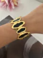 Elegante brede vergulde open armband voorzien van zwarte onregelmatige emaille patronen - Onregelmatige Ovaal Zwart