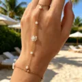 Elegant gold-tone finger bracelet featuring white flower beads and pearls on hand - White Artificial Pearl Hand Chain