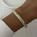 Close-up of a vintage enamel bracelet with colorful floral patterns on a woman's wrist - 6CM Diameter / Creamy White Floral (BR26Y0269-1)