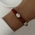 Macro detail of a vintage red enamel bangle with white floral patterns - 6CM Diameter / Deep Red Rhinestone Floral (BR26Y0269-3)