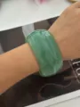 Bracciale largo in resina verde traslucida con trama finta agata indossato al polso. - Verde Marmorizzato Largo
