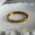 Elegante bracciale elastico dorato con vivaci ciliegie in smalto rosso su una fascia liscia - Bracciale Elastico Motivo Ciliegia (A849)
