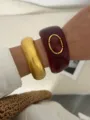 Close-up detail of chunky gold and burgundy resin bangles in bohemian ethnic style - Wine Red and Shiny Gold Combination