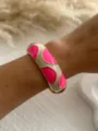 Close-up detail of a vibrant rose pink and cream enamel dopamine style bangle on wrist - Fuchsia White Semicircle 3556