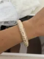 Elegant ivory enamel bamboo-style bangle with gold geometric patterns on model wrist - Geometric Greek Key Style / White Gold