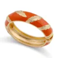 Detaillierte Makroansicht eines orangefarbenen Emaille-Armreifs mit Goldfedergravur - Orange Emaille Gold Feder