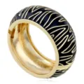 Vista dettagliata del bracciale rigido dorato largo con strisce zebrate in smalto nero. - Motivo Zebra Nero e Oro