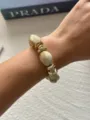 Bohemian vintage style cream beaded bracelet with gold finish worn on a female wrist - Milk Coffee