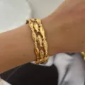 Elegante bracciale dorato a tema pesci dell'oceano, perfetto per un look da vacanza. - Stile Pesce / Oro