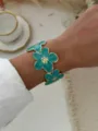 Elegante bracciale rigido largo con fiori in smalto verde acqua e finitura placcata oro - Bracciale Rigido Fiore Smalto Ciano