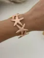 Elegante bracciale rigido aperto con stelle marine in smalto rosa e finitura dorata - Bracciale Rigido Stella Marina Smalto Rosa