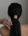 Vue détaillée d'un bijou de queue de cheval doré martelé élégant sur des cheveux noirs. - Accessoire Cheveux Queue de Cheval Martelé (2025331-331) / Or