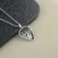Stainless steel guitar pick pendant necklace for men with music note design detail close up - Keel Chain Style