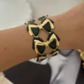 Eleganter breiter Armreif mit schwarzer Emaille-Schleife in Goldoptik für Retro-Stil - Schwarzer Schleifenstil
