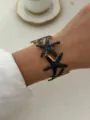 Eleganter Armreif mit schwarzen Emaille-Seesternen und vergoldeter Oberfläche für Damen - Schwarze Glasur Seestern Offener Armreif