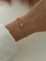 Elegant minimalist gold-plated copper flower bracelet with zircon charm worn on a wrist - Flower Bracelet Style (A720-7)