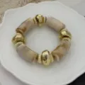 Elegant beige marmeren hars kralenarmband met goudkleurige getextureerde metalen kralen - Marmer Wit Stijl