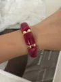 Leuchtendes magentafarbenes, breites, elastisches Armband mit goldenen Perlen am Handgelenk - Bonbonfarbe Perlen Elastisches Armband (Rosarot)