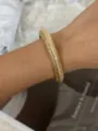 Eleganter klobiger goldfarbener strukturierter elastischer Armreif am Handgelenk einer Frau - Feiner Horizontaler Rippenbreiter Armreif (A657 Gold)
