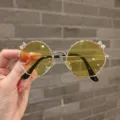 Detail view of cute yellow children's sunglasses with sparkly bow accents on metal frame. - Gold Frame Yellow Lens