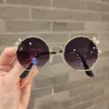Primer plano de gafas de sol para niños con lentes moradas degradadas y detalles de lazo - Montura Dorada Lente Degradado Púrpura