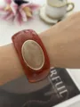 Bracciale largo in resina ambrata con intarsio in pietra ovale - Marrone Rossastro
