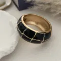 Dettaglio di un bracciale rigido dorato vintage con motivo a piastrelle in smalto nero - Stile Griglia Nero e Oro (3556) / Oro