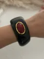 Dettaglio di un bracciale a polsino in resina nera con finta pietra rossa in stile retrò - Nero (1582)