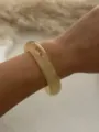 Primo piano di un bracciale rigido in resina marmorizzata vintage indossato al polso. - Ambra (1525397)