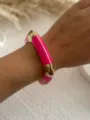 Close-up detail of a vibrant fuchsia and gold enamel chunky bangle worn on a wrist - Fuchsia 2583