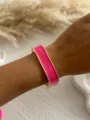 Close-up of a pink enamel bangle bracelet with gold-tone edges worn on a wrist. - Geometric Faceted Style / Fuchsia Square 4551