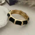 Gedetailleerde macro-opname van vintage gouden bamboe armband met zwart emaille lak - Zwart Goud Bamboeknoop Stijl (157) / Goud