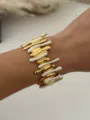 Brazalete abierto de acero inoxidable con esmalte goteante dorado y blanco único. - Oro Blanco Columna Irregular