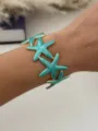 Elegant turquoise marbled starfish open cuff bracelet with vintage gold-plated edges on wrist - Blue Gold Starfish Style