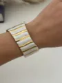 Bracciale rigido aperto ondulato in acciaio inox con intarsi in marmo bianco e dorato - Oro Bianco Righe Verticali