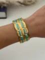 Vintage gold-plated stainless steel cuff bracelet with turquoise enamel on model - Blue Gold Brick Pattern Style