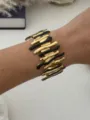 Markantes Edelstahl-Armreif mit gold-schwarzem Wellenmuster, am Modell-Handgelenk - Schwarz Gold Unregelmäßige Säule
