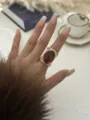 Vintage gold-tone oversized resin ring with dark amber oval cabochon shown on model - Oval Resin Geometric Ring (0981) / Amber
