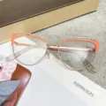 Orange and rose gold cat-eye blue light blocking glasses on lifestyle background - Rose Gold Pink / Photochromic Lenses