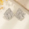 Detalle macro de pendientes plateados con textura arrugada y forma de rombo geométrico - Pendientes de Botón de Rombo Plisado Irregular (853263) / Plateado