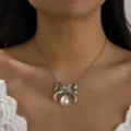 Elegante Halskette mit silberner Schleife und weißer künstlicher Perle an einem Model - Halskette (656475) / Silber