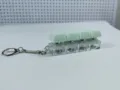 Primo piano di un portachiavi fidget a 4 tasti meccanici con copritasti verde menta - Stile a Quattro Tasti con Copertura Spessa / Con Luce / Verde Chiaro