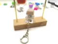 Detail view of transparent mechanical switch fidget keychain with a beige keycap set - Brown