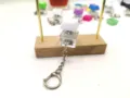 Close-up of mechanical keyboard switch fidget keychain with white keycap and transparent base - White