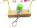 Detailed view of a green mechanical keyboard switch fidget toy keychain on wood - Grass Green
