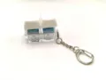 Detail view of a glowing mechanical keyboard switch keychain with white keycaps and blue switch. - Solid Color With Light 2-Key - White