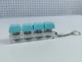 Close-up detail of a four-key mechanical switch fidget keychain with light blue keycaps - Four-Key Thick Cover Style / No Light / Cyan