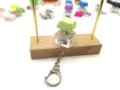 Close-up of a green mechanical keycap switch keychain on a wooden stand - Light Green